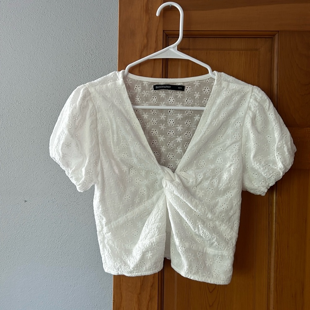 White shirt. Puffed sleeves, knotted in the middle. elastic  at back waistband.